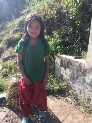 A small girl in a green shirt and red pants